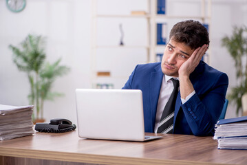 Fototapeta premium Young male employee and too much work in the office