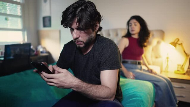 Young man ignoring woman while using smartphone device. Couple in crisis because of modern technology. Girlfriend ignored by boyfriend