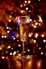festive flute of sparkling champagne against a backdrop of bokeh of Christmas lights. .