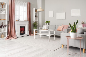 Interior of living room with modern fireplace, different home decorations and sofas