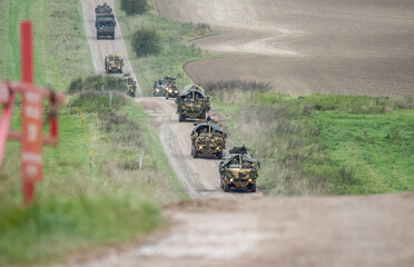 a convoy of camouflaged British army Supacat Jackals on a dirt road. Wilts UK