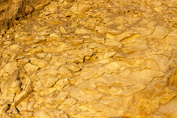 scree from the mountain on the shore stones from opoka at the golden hour, close-up texture - obrazy, fototapety, plakaty