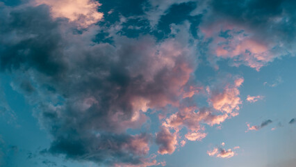Scenic rose golden glowing small clouds highlighted by Sunset. Close up panoramic aerial photo of...