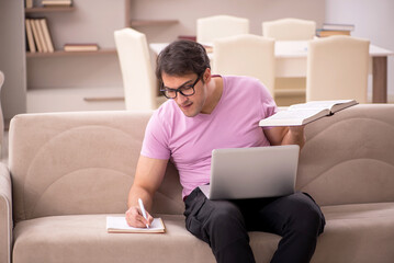 Young male student preparing for exams at home