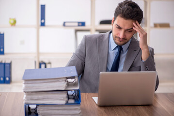 Young male employee and too much work in the office