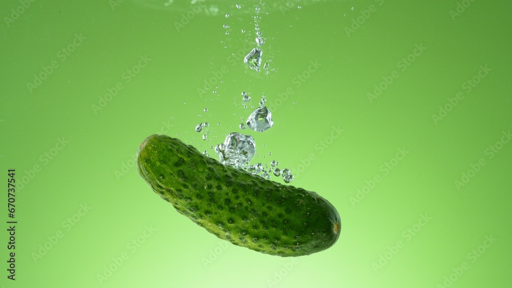 Poster raw cucumber falling into water.