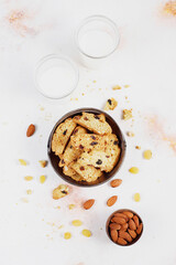 Italian raisin almond biscotti and glass of milk on light background.