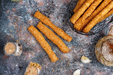 Italian grissini or salted bread sticks with sesame seeds. - obrazy, fototapety, plakaty