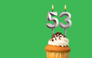 Birthday with number 53 candle and cupcake - Anniversary card on green color background