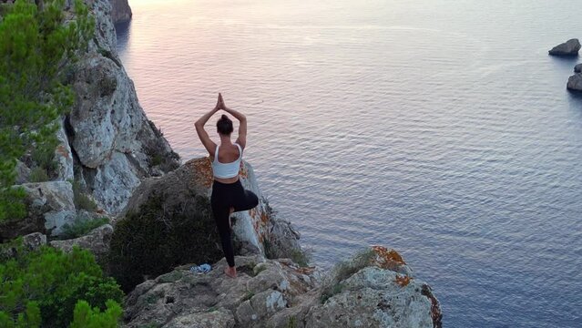 Fabulous aerial view flight drone Ibiza cliff female yoga model sunset evening