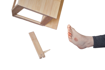 Woman injured foot on leg after falling from wooden stepladder, isolated on a white background. The problem with labor protection at diy work at home