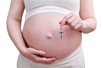A symbol of the Christian religion in the hands of a pregnant woman, a studio photo, isolated on a white background