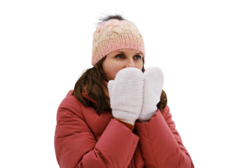 Portrait of an adult woman in a winter jacket against the background of snowy nature, isolated on white background. A woman holds warm mittens to her face for warmth