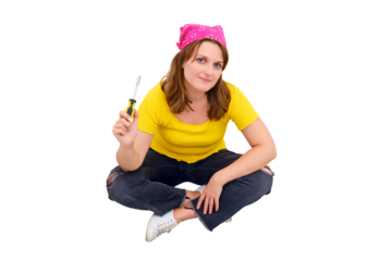 A young woman sits on the floor next to a tool kit with a screwdriver in her hands, isolated on a white background