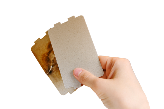 Repair of a sparkling microwave by replacing the mica plate, isolated on white background. Broken microwave with self replacement burnt mica sheet
