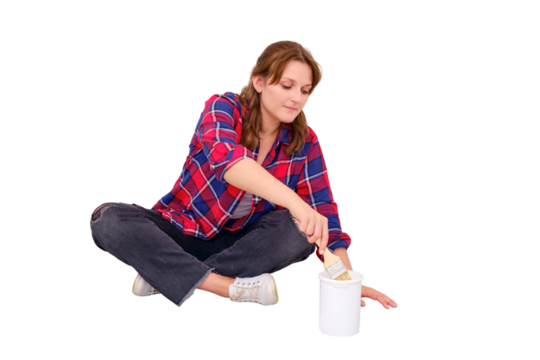 A woman dips a brush into a jar of white paint, isolated on a white background. Painting work in the repair of the apartment