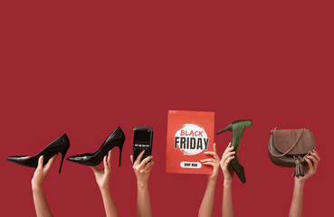 Female hands holding poster with text BLACK FRIDAY, payment terminal and women accessories on red background