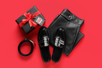 Composition with stylish female shoes, clothes and gift box on red background. Black Friday sale