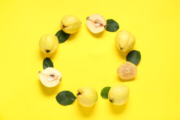 Frame made of sweet ripe quinces and leaves on yellow background