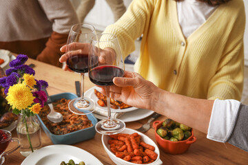 Young woman with her mother having dinner at festive table on Thanksgiving Day, closeup
