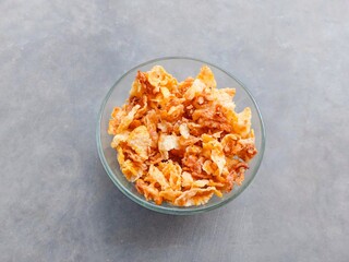 bowl of sweet corn on gray background.  spicy and sweet corn chips. crushed corn chips.