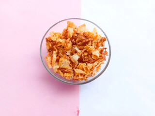 spicy and sweet corn chips in glass bowl on pink and white background. crushed corn chips. Sweet and spicy snacks