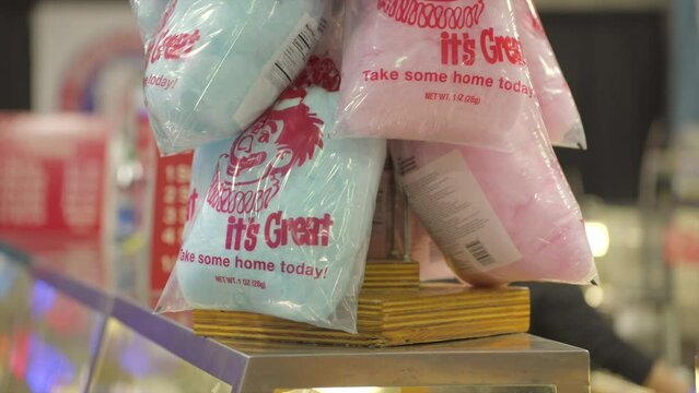 This close up video shows bags of classic pink and blue cotton candy on a rack.