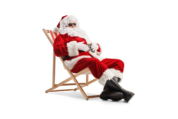 Santa claus wearing sunglasses and sitting on a deck chair