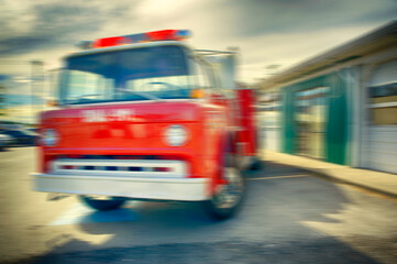 Blurred image of vintage firetruck and station.