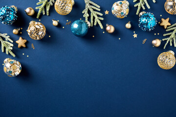 Luxury Christmas greeting card template with fir branches, golden ball ornaments, confetti on dark blue background. Merry Christmas and Happy New Year concept.