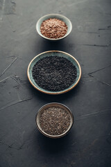 Black sesame, flax and chia seeds in ceramic plates