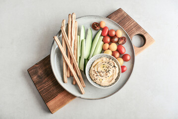 Bowl with hummus, cucumber, cherry tomatoes and crispbread