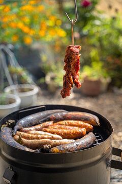Asado de barril con costilla de cerdo y chorizo en cilindro peruano