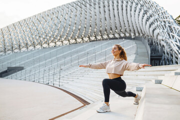 Athletic woman performs sports exercises outdoors. A young female athlete in special clothing is...