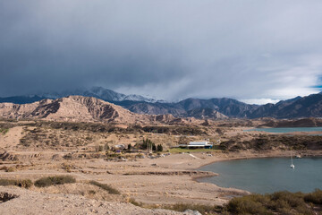 Mountain lake with crystal clear blue water surrounded by red mountains
