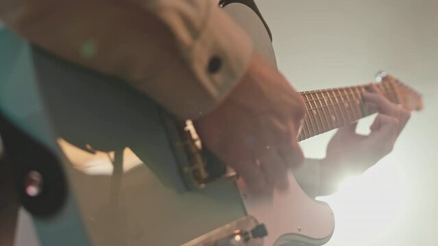 Close up shot of hands of musician playing electric guitar on rehearsal