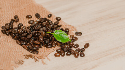 Brown roasted coffee beans on wooden table.