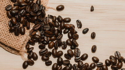Brown roasted coffee beans on wooden table.