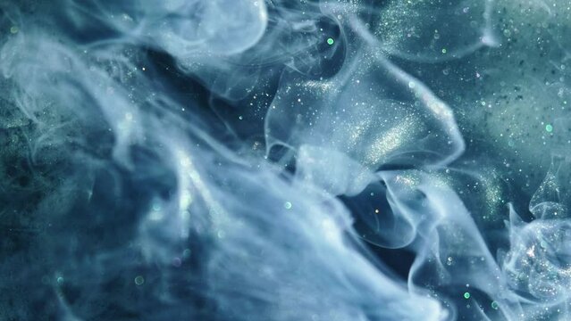 Vertical video. Color smoke background. Ethereal wave. Blue teal green shimmering glitter paint flow spreading in water hypnotic mysterious magic abstract art.
