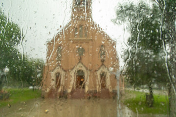 View of a Catholic Church in Strasburg, North Dakota through a Rain Streaked Window