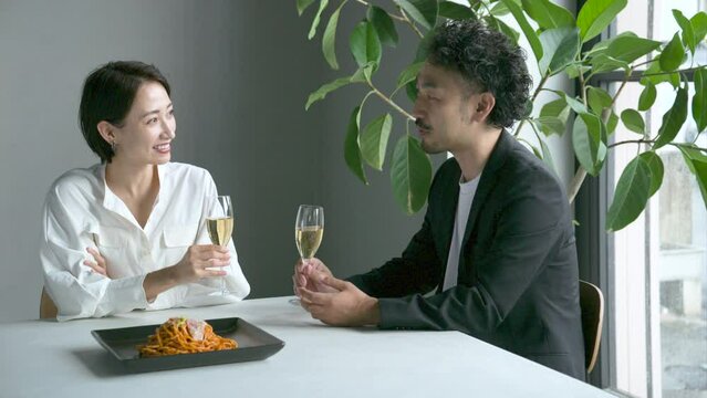 レストランで食事する見つめ合う男女　ワイングラスを持つ　デートや夫婦の様子	
