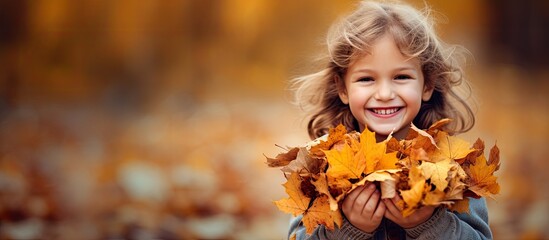 Child happily collecting and cherishing colorful autumn leaves embracing the beauty of nature - obrazy, fototapety, plakaty