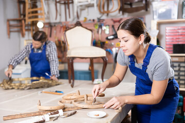 Fototapeta na wymiar Portrait of skillful repair woman carpenter renovating chair furniture using tools in woodwork studio