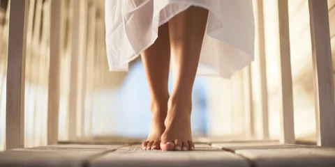 Foto auf Acrylglas Close-up of healthy ladies legs at spa wearing dressing gown, walking on rustic floor © David