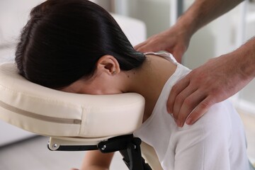 Woman receiving massage in modern chair indoors, closeup - obrazy, fototapety, plakaty