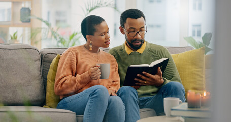 Home, relax and black couple on a couch, bible and reading with religion, love and bonding together. Romance, apartment or man with woman, scripture and holy book with Christian, hope or conversation