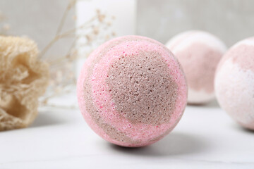 Pink bath bomb on white table, closeup