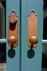 Closeup of double door with knobs, brass backplate and lock