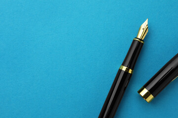 Stylish fountain pen with cap on light blue background, flat lay. Space for text