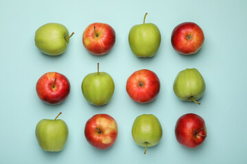 Fresh colorful apples on light blue background, flat lay